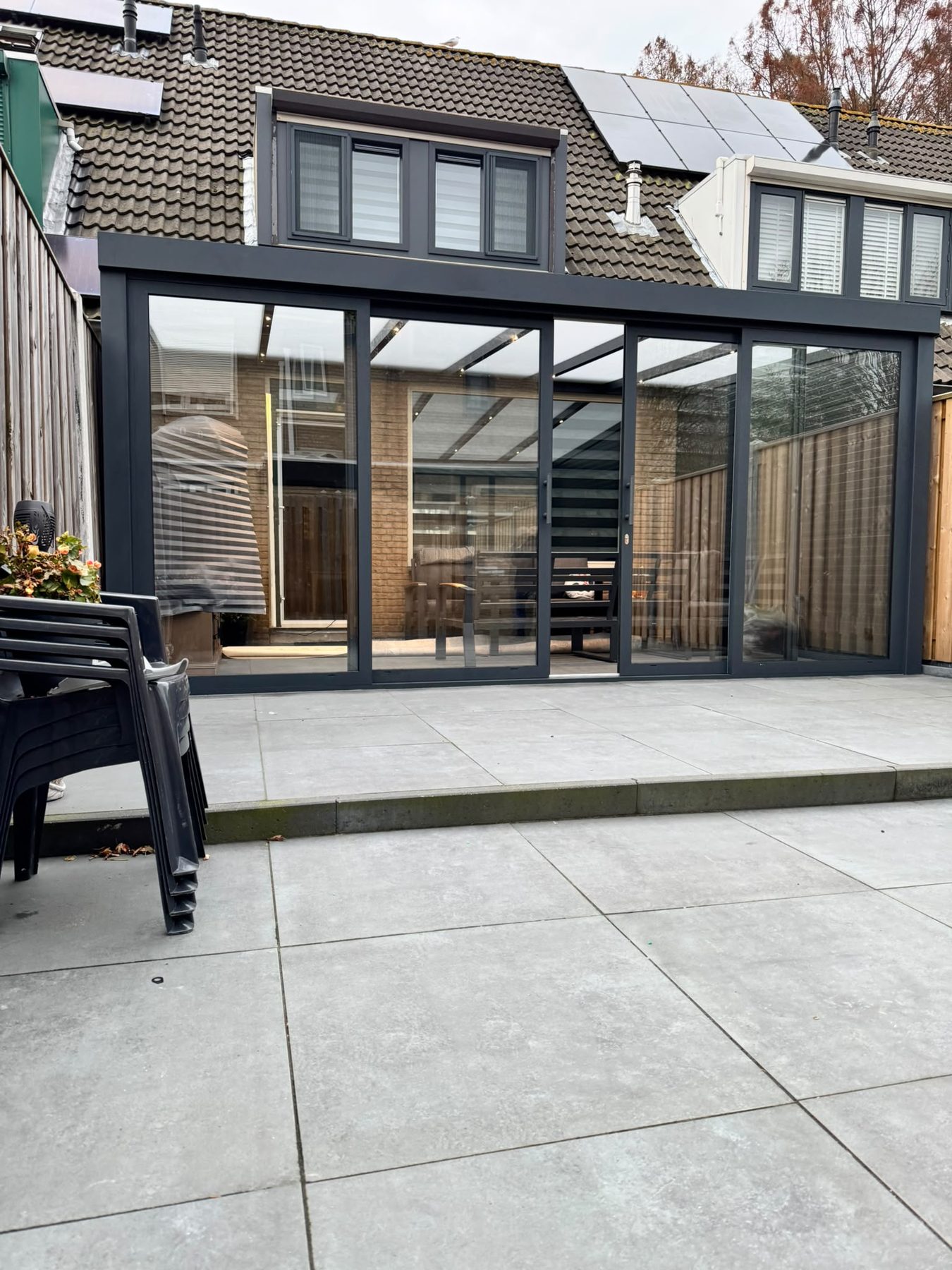Houten overkapping met glazen dak boven een terras